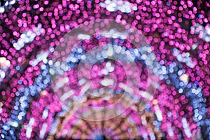 Blurred garland as arc or semicircle. City night light blur bokeh, defocused background. Holiday abstract pattern