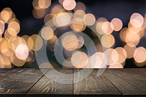 Blurred gold garland and wooden tabletop as foreground. Image for display your christmas products