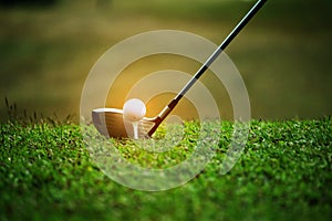 Blurred golf club and golf ball close up in grass field