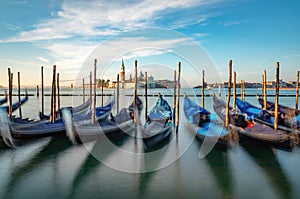 Blurred gondolas at San Marco with view in early morning to island San Georgio Maggiore in Venice