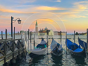 Blurred gondolas at San Marco with view in early morning to island San Georgio Maggiore in Venice