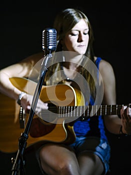 Blurred guitarist behind vintage microphone