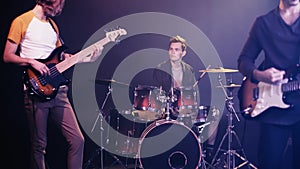 blurred guitarists and drummer performing on
