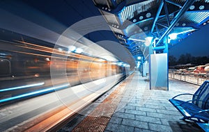 Blurred high speed train on the railway station at night