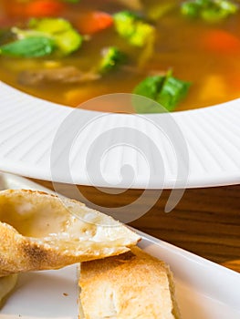 Blurred Homemade Hot soup with Vegetables, green vegearian soup, crackers with cheese, selective focus