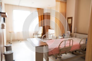 Blurred hospital indoor room with bed and window with lush sunlight