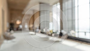 Blurred hotel or office building lobby blur background interior view toward reception hall, modern luxury white room