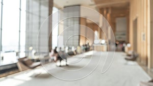 Blurred hotel or office building lobby blur background interior view toward reception hall, modern luxury white room