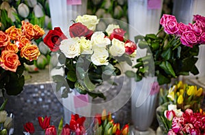 Blurred image of bouquet of fresh roses and tulips in flower shop. Lot of multicolored roses and tulips bouquets