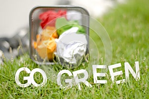 Blurred image of crumple paper in thrash can with alphabet GO GREEN