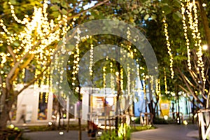 Blurred image Decorative outdoor string lights hanging on tree in the garden at night time festivals season - decorative Christmas