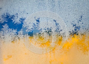 Blurred image Flag of Ukraine, Hoarfrost on glass, frost, cold. Yellow-blue background.  Symbol, poster, banner of the national fl