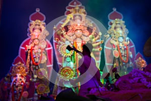 Blurred image, Goddess Durga is being worshipped by Hindu priest with mirror. Vog, the holy food is being offered to Durga.