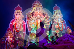 Blurred image, Goddess Durga is being worshipped by Hindu priest with mirror. Vog, the holy food is being offered to Durga.