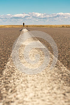 Blurred image of a man cyclist on a sunny summer day cycling in the middle of the road.