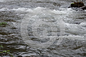 Blurred image of the movement of water in a beautiful forest river with a waterfall