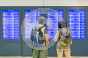 Blurred image of passenger looking timetable screens in airport