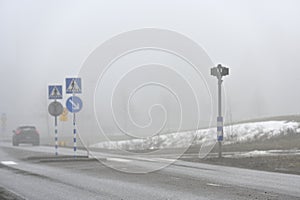blurred image of a pedestrian crossing and a car in the fog