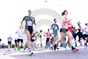 Blurred image of people running in massive marathon on a sunny summer day.