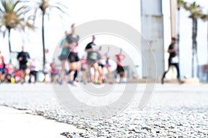 Blurred image of people running in massive marathon on a sunny summer day.