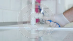 Blurred Image with Person Hands Wearing Protective Yellow Household Gloves Cleaning the Kitchen Furniture