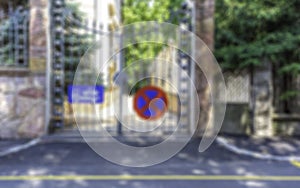 Blurred image of private house estate entrance with no parking sign and truck towing sign on house gate background backdrop