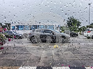 Blurred Image - Rainy season - Rain drops stuck the car window, Blurred car on the road at Thailand in rainy day, The car caught