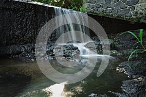 Blurred image of a small river waterfall close-up, long exposure,