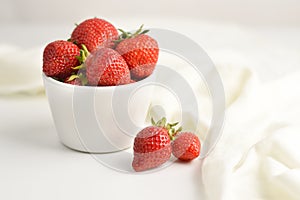 Blurred image of strawberries in a white dish on a white background with space for writing text