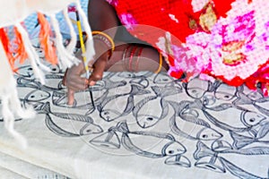 Blurred image, young Bengali female artist painting fishes, Pattachitra or Patachitra - traditional, cloth-based scroll painting