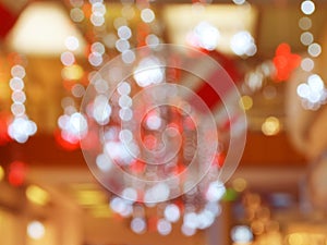 Blurred interior with bokeh: shopping center festively lit and decorated with shiny garlands for holidays, Christmas a