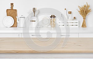 Blurred kitchen counter with utensils and ingredients over wooden table