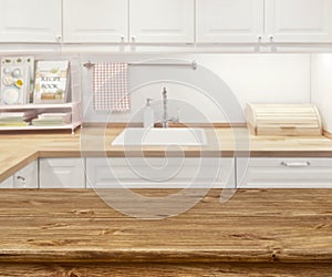 Blurred kitchen interior with wooden dinning table in front