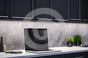 Blurred laptop with blank screen in modern kitchen. Mock up