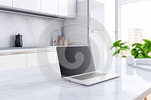 Blurred laptop with blank screen on white marble table in modern kitchen. Mock up.