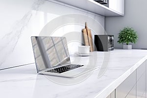 Blurred laptop on white marble countertop in modern kitchen.