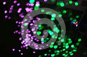 Blurred LED screen closeup. Glowing threads in a color spectrum on a black background