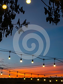 Blurred of light bulbs with twilight colorful sky in courtyard for background