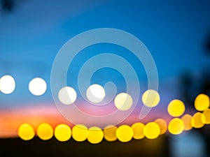 Blurred of light bulbs with twilight colorful sky in courtyard for background