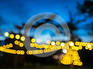 Blurred of light bulbs with twilight colorful sky in courtyard for background