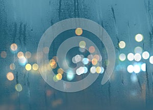 Blurred light at rainy season evening windows with rain drops  lamp light background abstract template