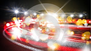 Blurred light trails from moving vehicles create dynamic patterns on dark road