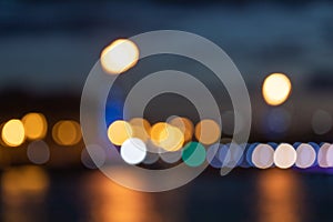 Blurred lights of a big city at night, reflection of lights in river water, night cityscape