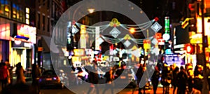 Blurred lights of a street scene with people and cars in Manhattan New York City at night