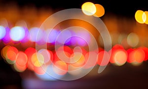 Blurred lights of headlights of cars and lanterns in the night city. Abstract bokeh