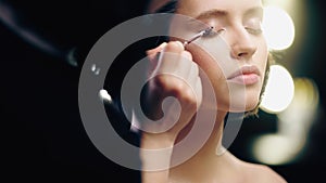 blurred makeup artist applying liquid eye