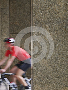 Blurred Man Cycling Between Pillars In Portico