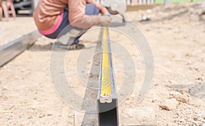 Blurred man workers use measuring tape to measure length of steel part in homebuilding. Construction labor hands use steel tape to