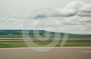 Blurred motion blur photo of autobahn railroad . Huge white clouds above