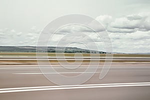 Blurred motion blur photo of european green nature offroad city autobahn railroad , huge white clouds on blue sky